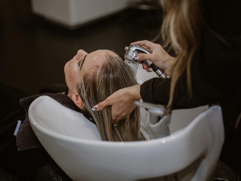 Hair stylist washing a client's hair at a beauty salon